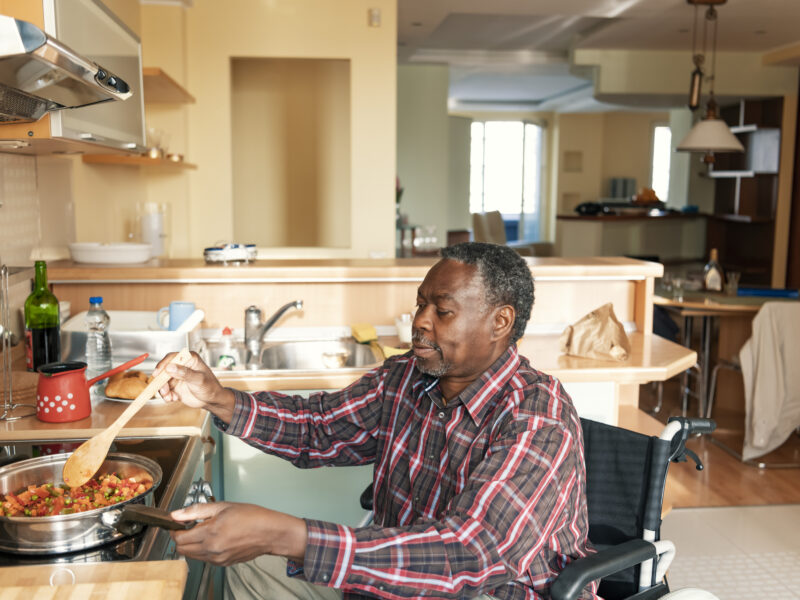 Senior Afro-American in Wheelchairs is Preparing a Lunch at Home