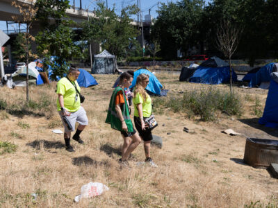 Image of outreach workers engaging with people in a homeless encampment.