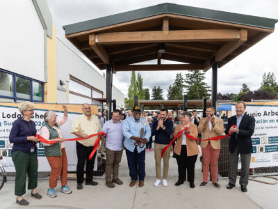 Group of people cut ribbon outside shelter