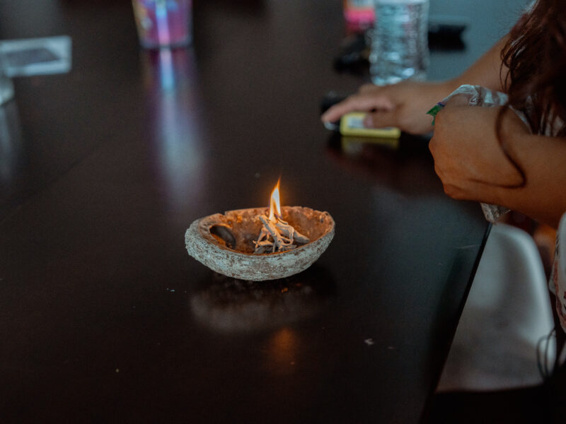 Sage burns in an abalone shell on a table.