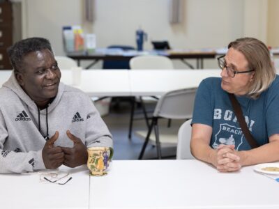 Two people sit at a table and talk to each other