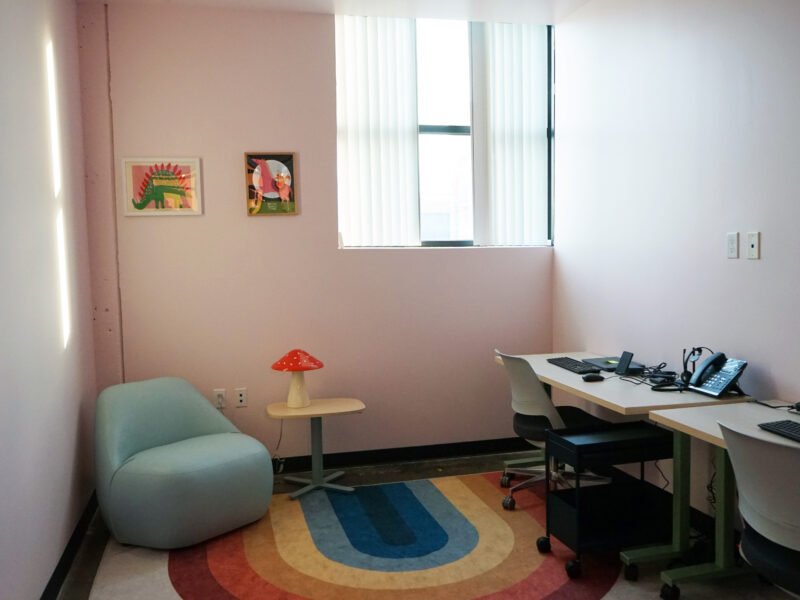 An office with colorful walls and a rainbow rug.